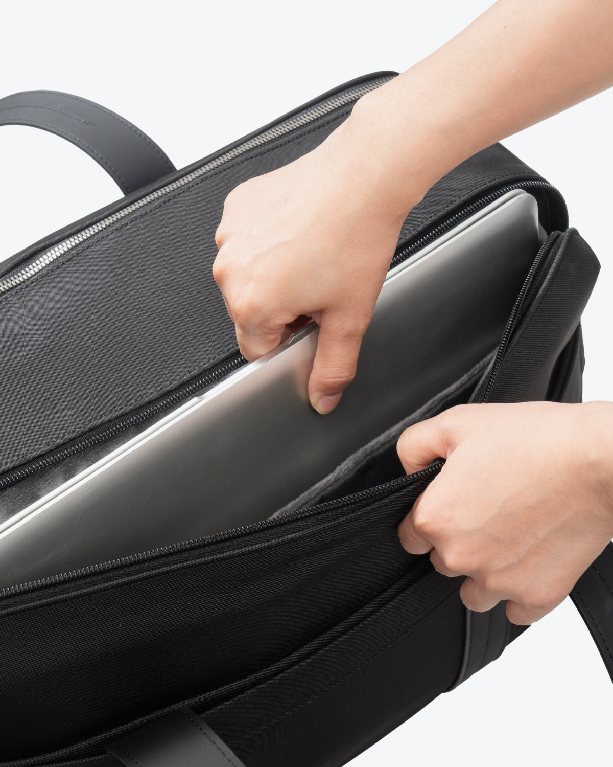 Inserting a laptop into the quick-access padded compartment of LEVEL8 CITYGO Bag